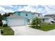 Charming two-story home featuring a two-car garage, palm tree, and well-manicured lawn on a sunny day at 336 Hollingshead Loop, Davenport, FL 33896