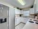 Bright kitchen with white cabinetry, stainless steel refrigerator, and modern appliances at 336 Hollingshead Loop, Davenport, FL 33896