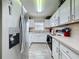 Functional kitchen showcases white cabinets, a stainless steel refrigerator, and essential appliances for convenient cooking at 336 Hollingshead Loop, Davenport, FL 33896