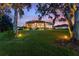 Lovely backyard featuring a screened-in lanai and mature trees on a well-manicured lawn at 346 Treviso Dr, Kissimmee, FL 34759