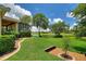 Expansive backyard features a lush lawn, mature trees, and a serene water view at 346 Treviso Dr, Kissimmee, FL 34759
