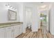 Bathroom with wood-look tile, granite counters, and entry to toilet and bedroom at 346 Treviso Dr, Kissimmee, FL 34759