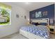 Cozy bedroom with blue accent wall, side tables with lamps, and a window with a view at 346 Treviso Dr, Kissimmee, FL 34759