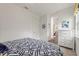 Bedroom featuring blue accent wall, white dresser, and view into kitchenette at 346 Treviso Dr, Kissimmee, FL 34759