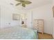 Bright bedroom with a decorative ceiling fan, a light wood dresser, and neutral carpet at 346 Treviso Dr, Kissimmee, FL 34759
