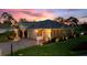 Elegant home exterior featuring a three-car garage, paver driveway, and well-kept lawn at 346 Treviso Dr, Kissimmee, FL 34759