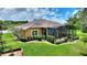 Aerial view of home featuring screened lanai, landscaped yard, and tile roof at 346 Treviso Dr, Kissimmee, FL 34759