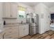 Bright kitchenette features stainless steel refrigerator, sink, and wooden-look tile flooring at 346 Treviso Dr, Kissimmee, FL 34759