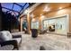 Covered patio with comfortable wicker furniture and travertine flooring, perfect for outdoor entertaining at 346 Treviso Dr, Kissimmee, FL 34759