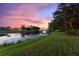 Picturesque twilight view of a tranquil pond with lush landscaping at 346 Treviso Dr, Kissimmee, FL 34759