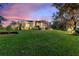 Exterior shot of a home with large back lawn, enclosed patio and mature landscaping at 346 Treviso Dr, Kissimmee, FL 34759
