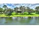 Scenic view of home on a lush green lawn with mature trees near a large pond at 346 Treviso Dr, Kissimmee, FL 34759