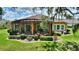 Home with a terra cotta colored tile roof, enclosed patio, and manicured shrubbery on a lush green lawn at 346 Treviso Dr, Kissimmee, FL 34759