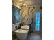 Bathroom showcasing a freestanding tub and a marble tiled accent wall illuminated by a modern chandelier at 3715 Sarasota Ct, Orlando, FL 32812