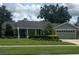 Single-story home with a well-manicured lawn, lush landscaping, and a two-car garage at 3715 Sarasota Ct, Orlando, FL 32812