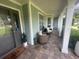 Charming front porch seating area with brick floors, neutral furniture, and view of lush landscape at 3715 Sarasota Ct, Orlando, FL 32812