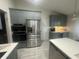Well-lit kitchen with grey cabinetry and stainless steel refrigerator at 3715 Sarasota Ct, Orlando, FL 32812