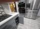 Modern kitchen featuring stainless steel appliances and grey cabinetry at 3715 Sarasota Ct, Orlando, FL 32812