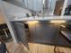 Kitchen island with grey cabinetry, storage drawers, white quartz countertop and breakfast bar seating at 3715 Sarasota Ct, Orlando, FL 32812
