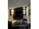 Modern living room with a black accent wall, built-in fireplace, flat-screen TV and comfortable seating at 3715 Sarasota Ct, Orlando, FL 32812