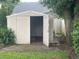Exterior view of the backyard shed that offers additional storage space, located beside some trees at 3715 Sarasota Ct, Orlando, FL 32812