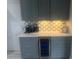 Wet bar area with wine cooler, quartz countertop, custom cabinets and accent backsplash at 3715 Sarasota Ct, Orlando, FL 32812
