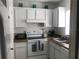 Functional kitchen with white cabinets and essential appliances for easy cooking at 4160 Pershing Pointe Pl # 1, Orlando, FL 32822