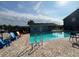 Community pool with lounge seating surrounded by black metal fencing at 4160 Pershing Pointe Pl # 1, Orlando, FL 32822