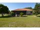 View of a spacious backyard, screened in lanai, with manicured lawn and landscaping at 455 Cinnamon Dr, Kissimmee, FL 34759