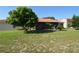 View of a spacious backyard, screened in lanai, manicured lawn, and mature trees at 455 Cinnamon Dr, Kissimmee, FL 34759