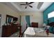 Bedroom with trey ceiling, dark wood furniture, and bright teal accent wall at 455 Cinnamon Dr, Kissimmee, FL 34759
