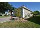 Side view of a house with a two-car garage, brick paved driveway, lawn, and decorative trees at 455 Cinnamon Dr, Kissimmee, FL 34759