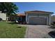 Charming single-story home featuring a two-car garage, brick paved driveway, and a well-manicured lawn at 455 Cinnamon Dr, Kissimmee, FL 34759