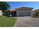 Charming single-story home featuring a red tile roof, brick driveway, and well-maintained landscaping at 455 Cinnamon Dr, Kissimmee, FL 34759