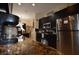 Open kitchen with stainless steel appliances, granite counters, and tile floors leading to dining area at 455 Cinnamon Dr, Kissimmee, FL 34759