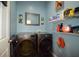 Bright laundry room with modern washer and dryer, shelving, and blue painted walls at 455 Cinnamon Dr, Kissimmee, FL 34759