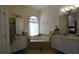 Bathroom with dual sinks, bathtub, and elegant fixtures with neutral tile floors at 455 Cinnamon Dr, Kissimmee, FL 34759