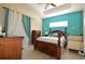 Cozy bedroom featuring a four-poster bed, tray ceiling, and large window at 455 Cinnamon Dr, Kissimmee, FL 34759