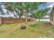 Spacious backyard featuring a fire pit, mature trees, a brick wall, and lush grass at 4828 Jeanette Ct, St Cloud, FL 34771