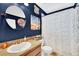 Unique bathroom with a round mirror, vanity, and shower with decorative artwork at 4828 Jeanette Ct, St Cloud, FL 34771