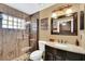Bathroom featuring glass enclosed shower with wood look tile, granite vanity, and decorative mirror at 4828 Jeanette Ct, St Cloud, FL 34771