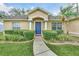 Charming home featuring a bright blue front door framed by manicured hedges and a brick-lined walkway at 4828 Jeanette Ct, St Cloud, FL 34771