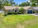 Well-maintained single-story home with lush green lawn, complemented by a blue front door and two-car garage door at 4828 Jeanette Ct, St Cloud, FL 34771