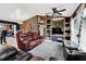 Cozy living room with brown walls, ceiling fan, built-in shelving, comfortable leather furniture, and a large window at 4828 Jeanette Ct, St Cloud, FL 34771