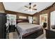 Spacious main bedroom with dark wood furniture, neutral bedding, ceiling fan and ensuite bathroom access at 4828 Jeanette Ct, St Cloud, FL 34771