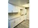 Kitchen with white cabinets, stainless steel sink, light countertops and backsplash, and stacked washer and dryer at 5967 Village Cir # Ge, Orlando, FL 32822