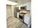 Bright kitchen with stainless steel appliances, sleek countertops, white cabinets and wood-look flooring at 5967 Village Cir # Ge, Orlando, FL 32822