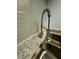 Close up of a stainless steel kitchen sink with a modern faucet, light granite countertop, and stylish backsplash at 5967 Village Cir # Ge, Orlando, FL 32822