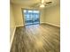 Bright living room features wood floors, neutral walls, and sliding glass door with vertical blinds at 5967 Village Cir # Ge, Orlando, FL 32822