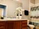 Neutral bathroom featuring a sink, decorative flowers, a black towel, and a tub with patterned curtain at 6100 Stevenson Dr # 202, Orlando, FL 32835